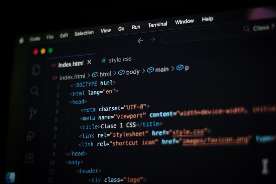 Close-up do código HTML exibido na tela de um computador em modo escuro, focando em conceitos de programação.