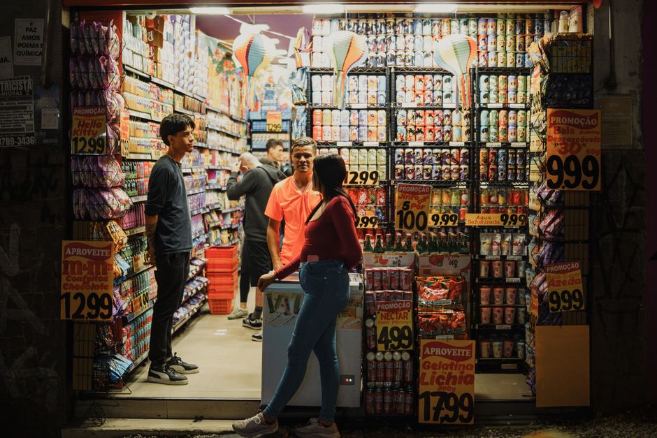 Cena vibrante da noite em um mercado de rua em São Paulo, Brasil, mostrando exibições coloridas e uma atmosfera animada.